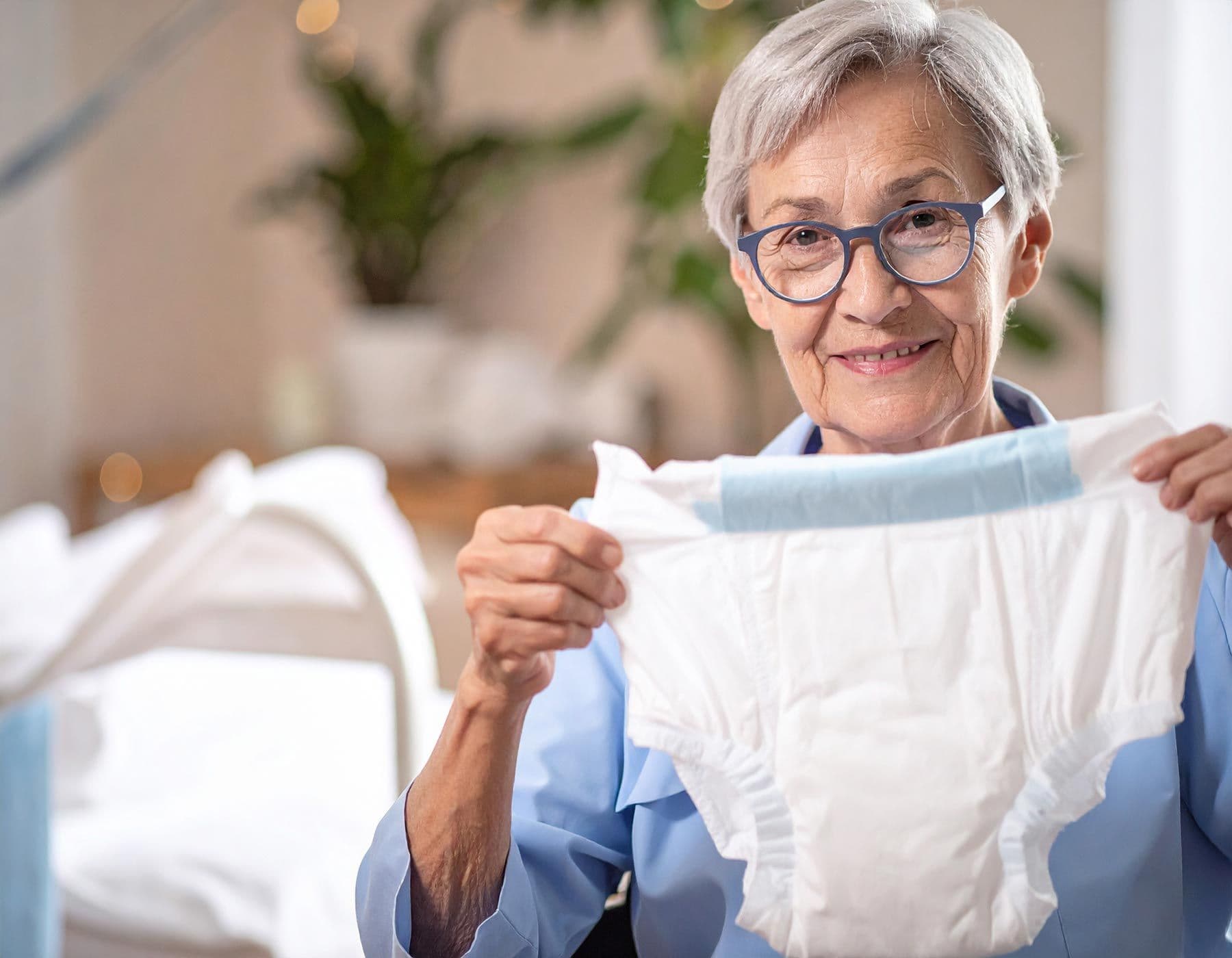 Ältere Frau hält eine Erwachsenenwindel vor sich