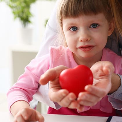Kleines Kind sitzt auf den Armen der Mutter