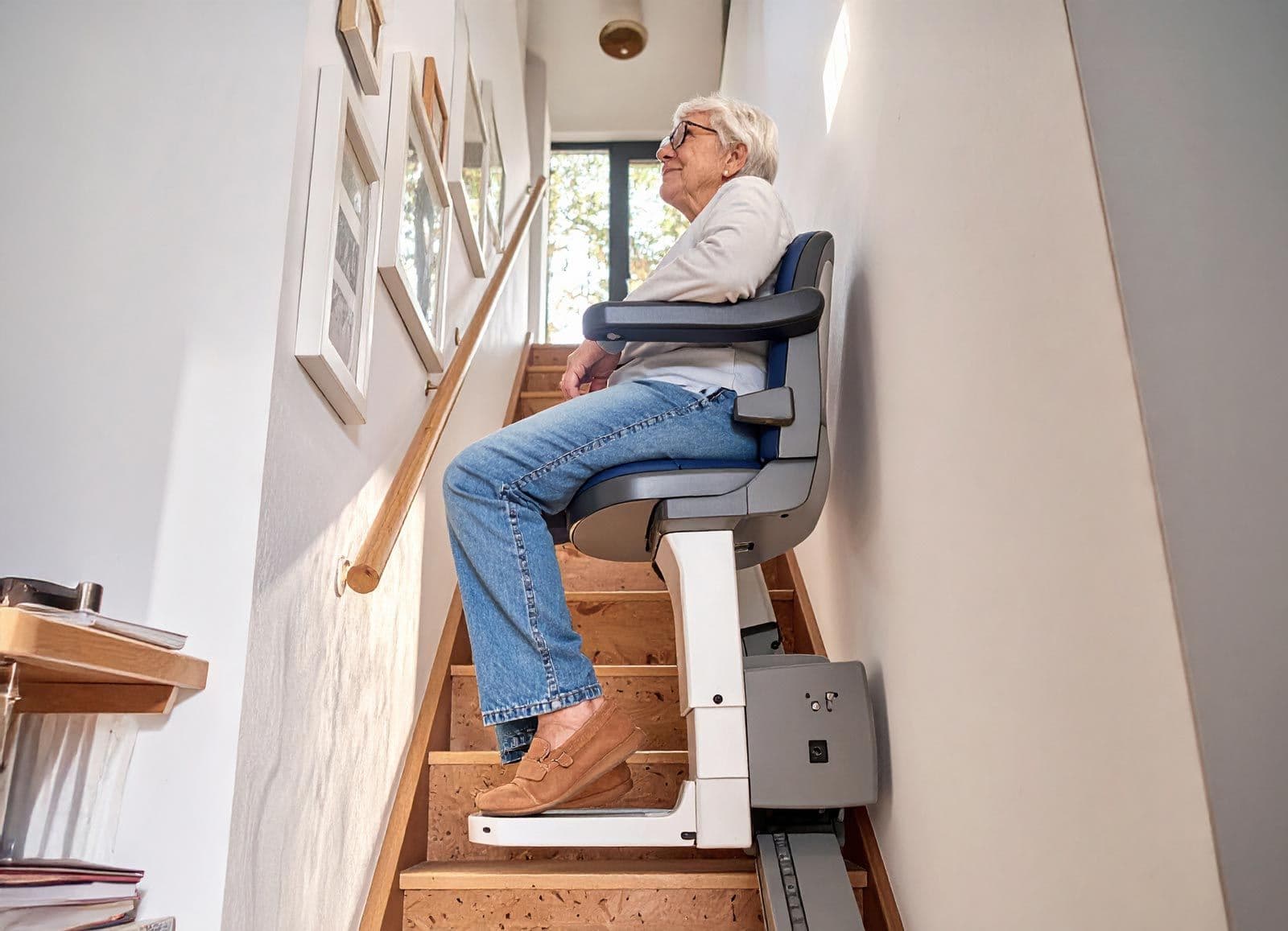 Seniorin sitzt auf einem medizinischen Treppenlift im Haus