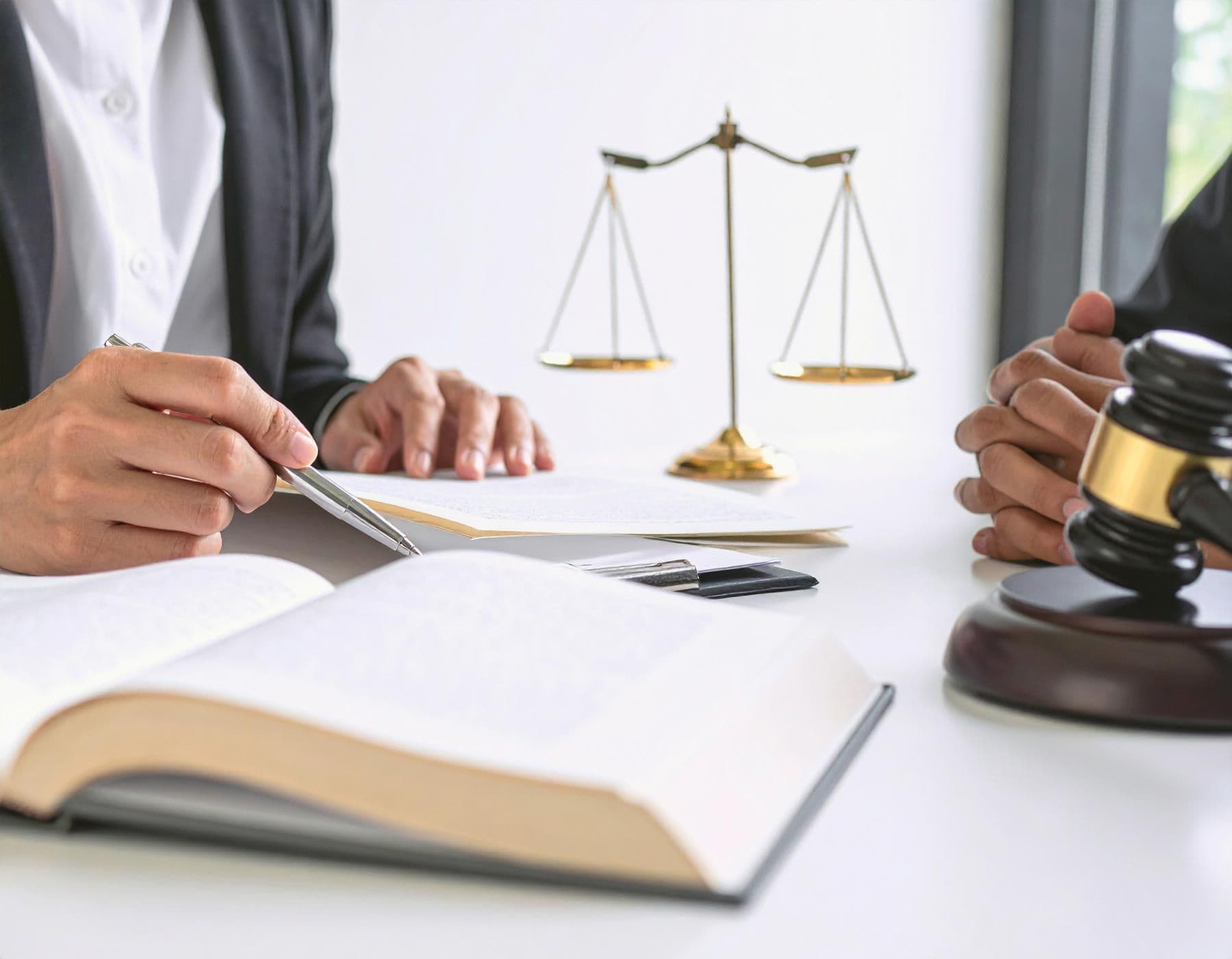 Nahaufnahme einer Hand eines Anwalts, der mit einem Stift auf Dokumente zeigt